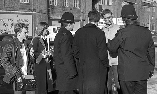 Rick Gibson talking to two police officers, two journalists and a lawyer