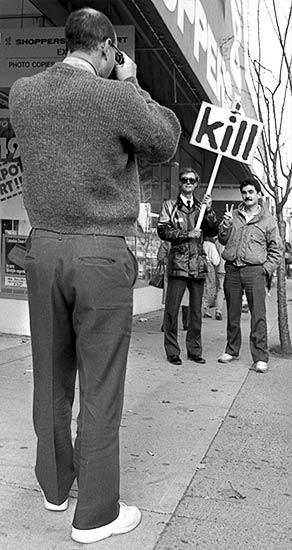 Black and white photo of a tourist from California taking a picture of Gibson with the man's friend