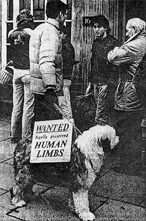 PICTURE: black and white newspaper photo of Rick Gibson talking with queue of people waiting to use a bank machine.  The on the dog's back reads - Wanted legally preserved human limbs.