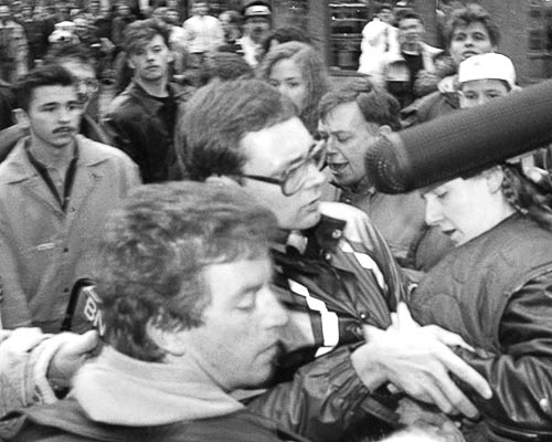 PICTURE: black and white photo of Paddy, Gibson and Susi being grabbed by protesters.